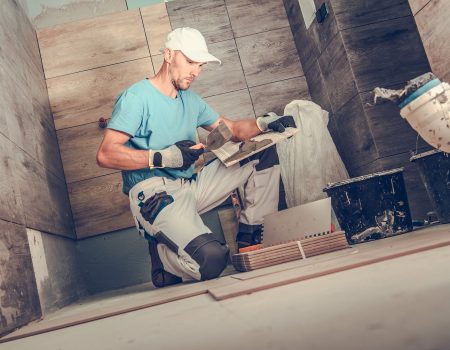 Bathroom Remodeling by Men. Caucasian Ceramic Tiles Installer During His Working Hours. Wooden Like Tiles.