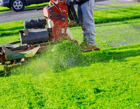 Man cutting lawn with using a gasoline mower in the home garden grass